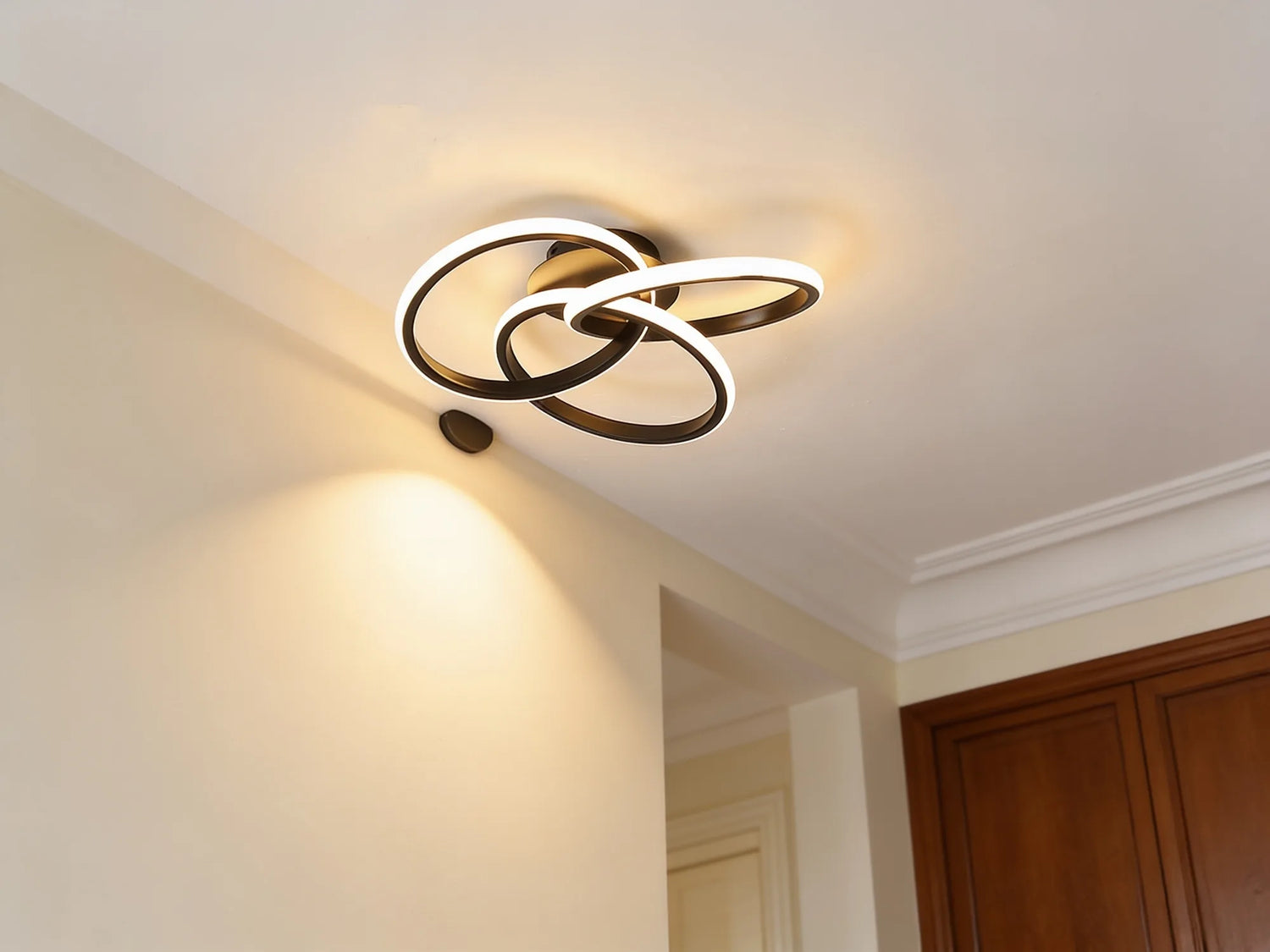 Le plafonnier allume en blanc chaud, nappe de lumiere sur un mur creme
