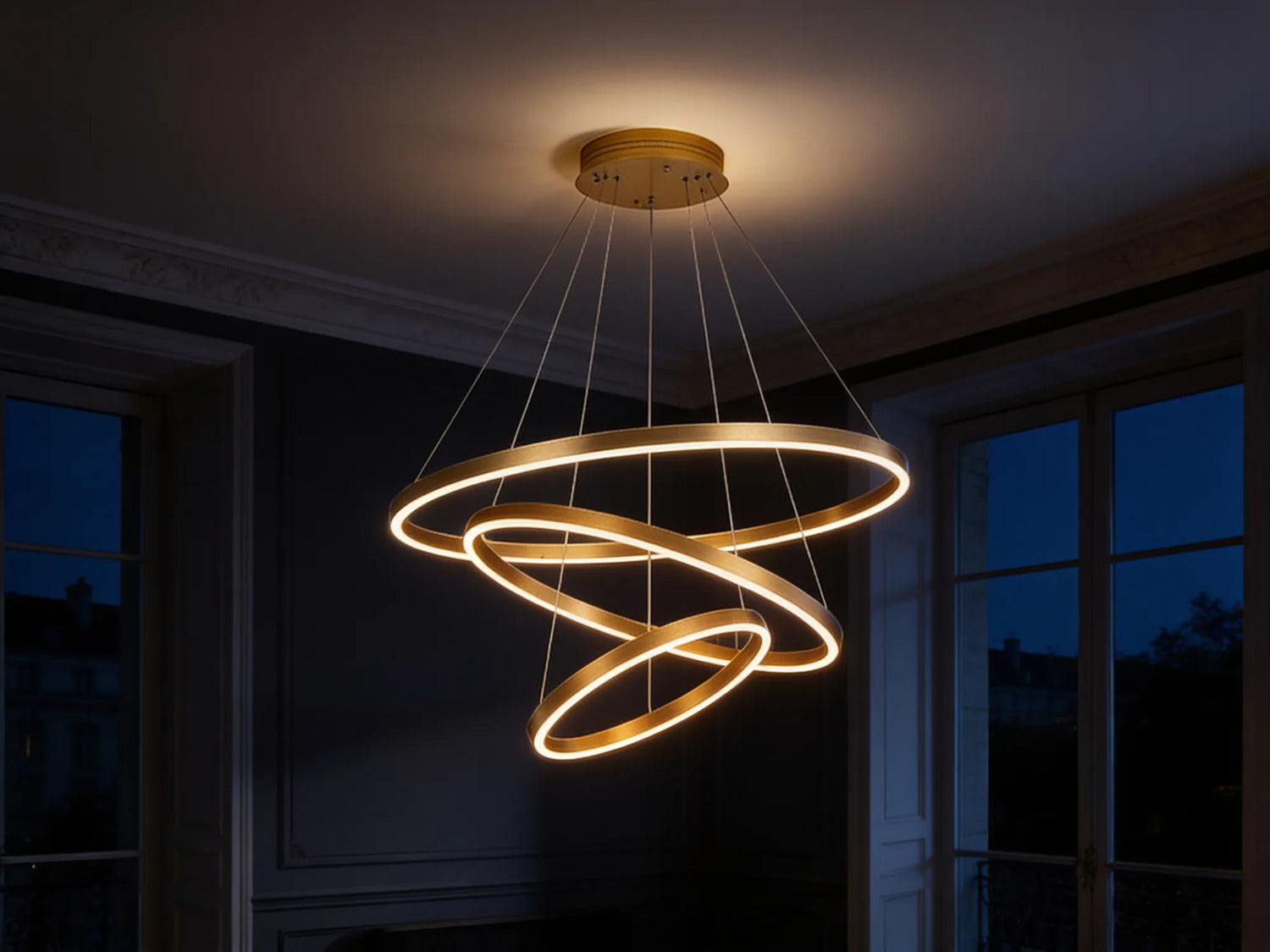 Le lustre seul allumé la nuit dans un intérieur haussmannien