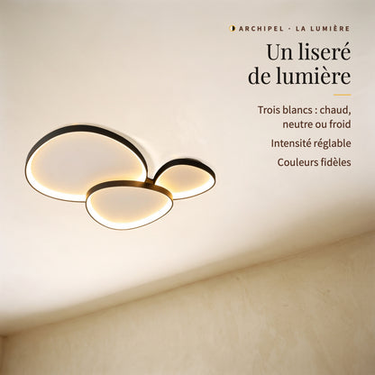 Archipel, trois galets allumés vus de biais : liseré de lumière, trois blancs, intensité réglable, couleurs fidèles