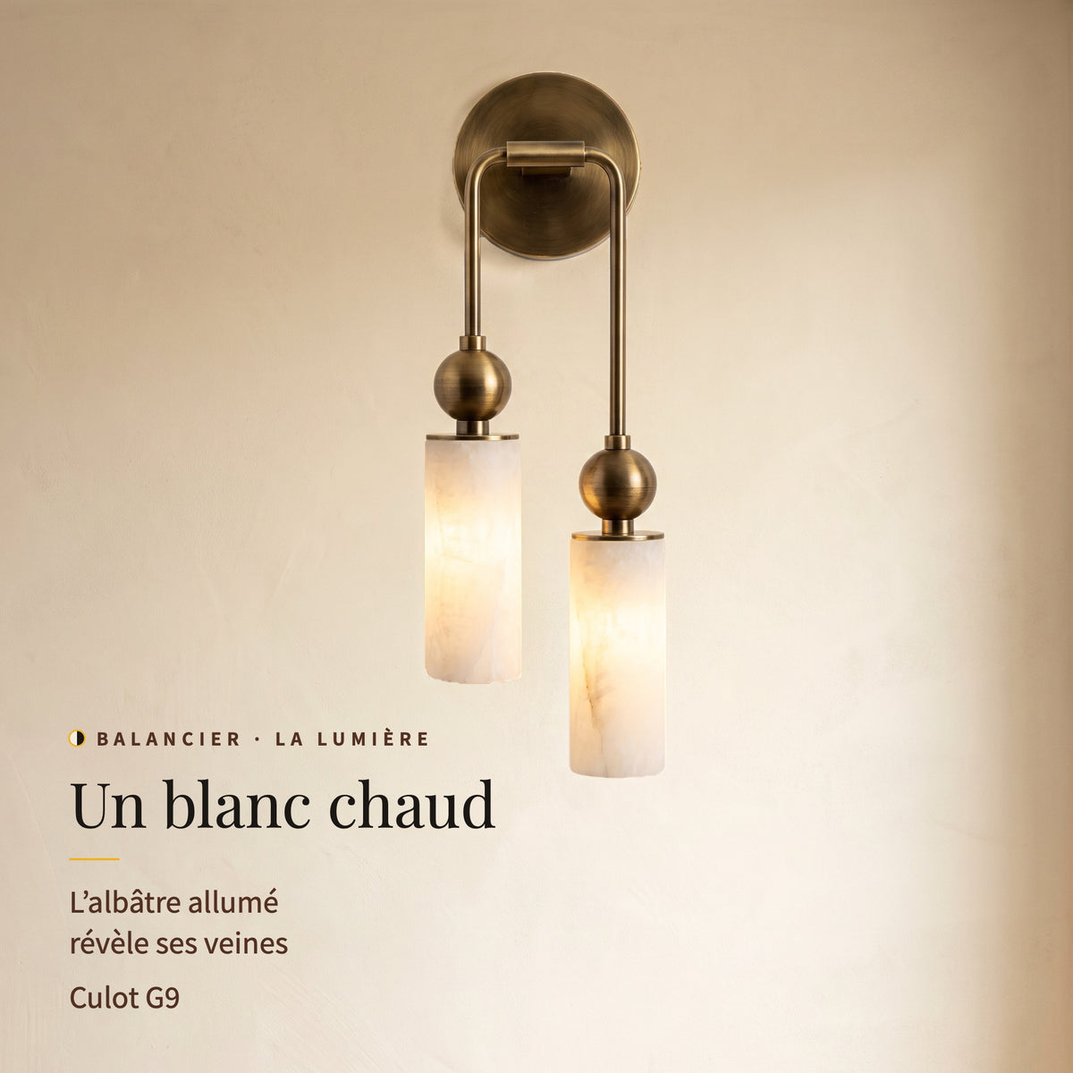 Balancier, applique allumée vue de face : lumière blanc chaud à travers l’albâtre veiné, culot G9