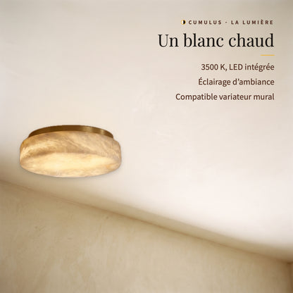 Cumulus, plafonnier en albâtre allumé vu de biais : blanc chaud 3500 K, LED intégrée, éclairage d’ambiance