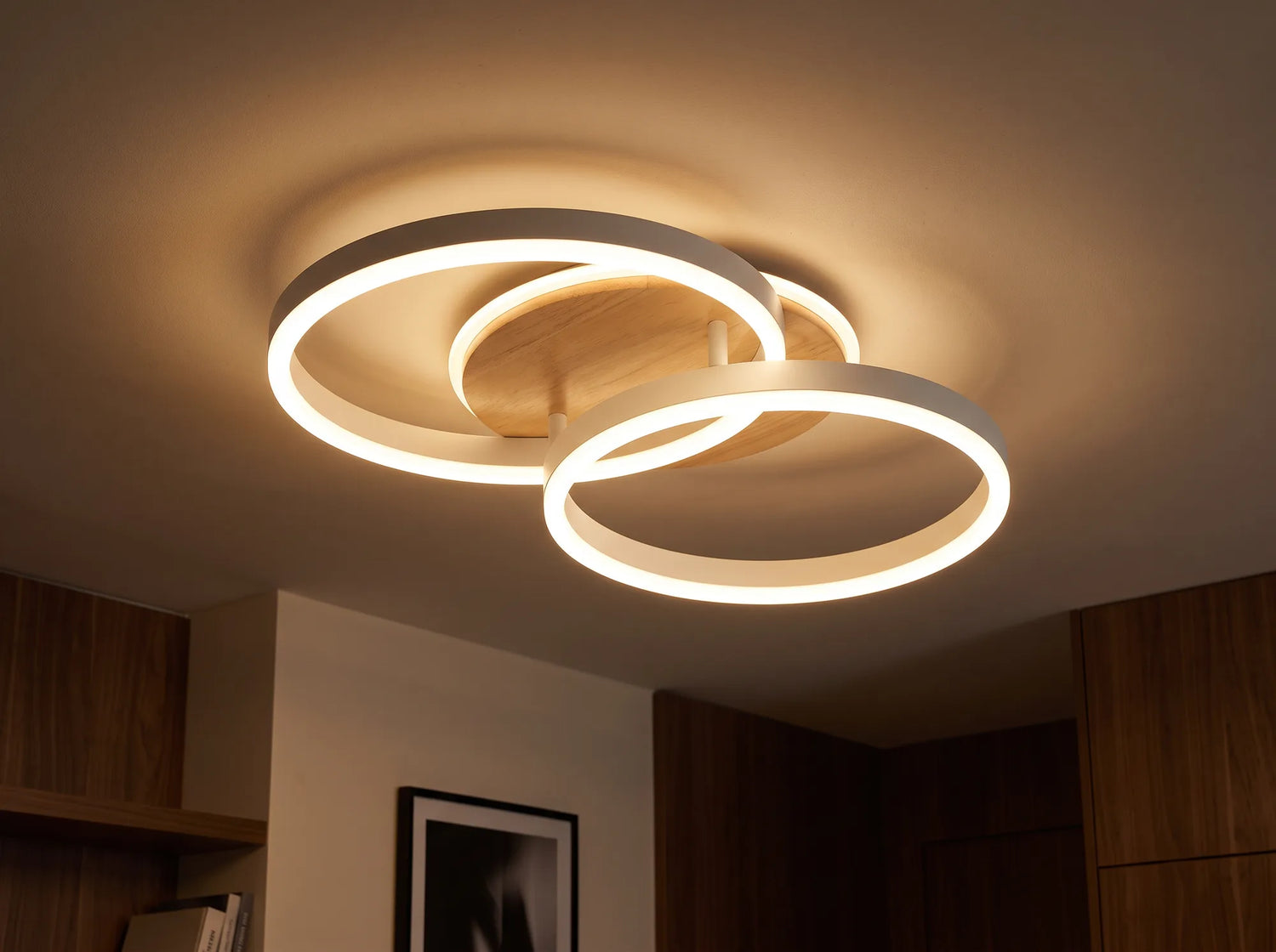 Le plafonnier a deux anneaux allumes en blanc chaud contre un plafond creme