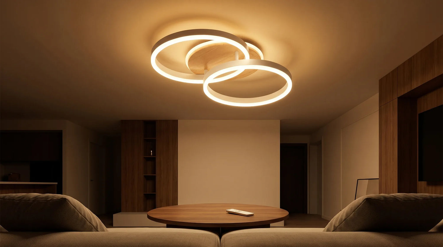 Salon eclaire par le plafonnier, telecommande posee sur une table basse ronde en noyer